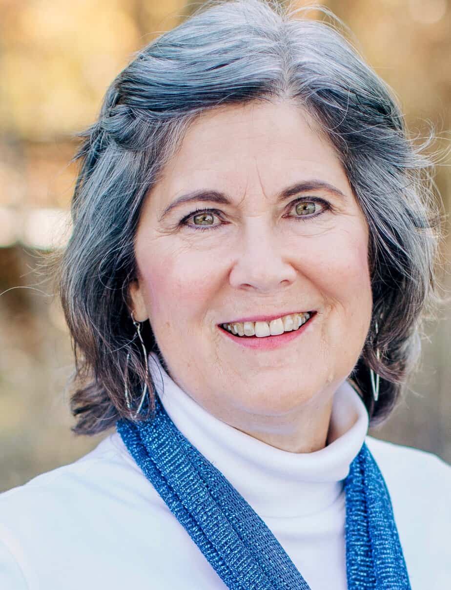 Let it Shine Photography Terri Ward functional nutritionist in a white shirt with a blue scarf an outdoor setting with fall colors