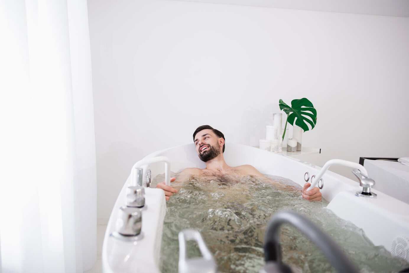 happy-man-turning-his-head-and-smiling-while-relax-2026-04-13-02-49-06-utc A man relaxing contentedly in a warm bath for gut health