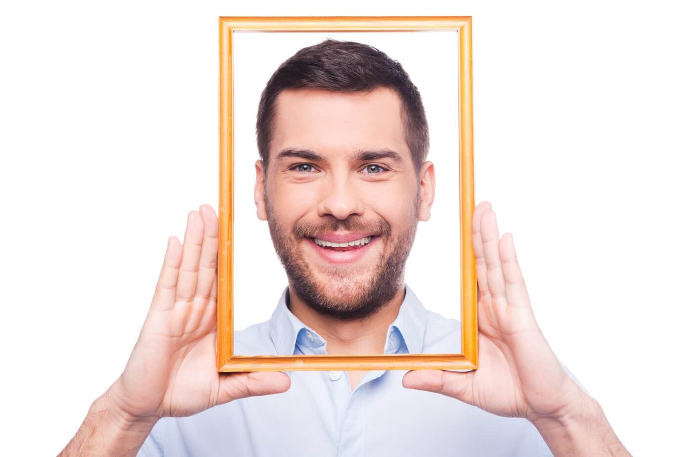 Man holding picture frame around his face, illustrating how reframing changes perspective without changing reality