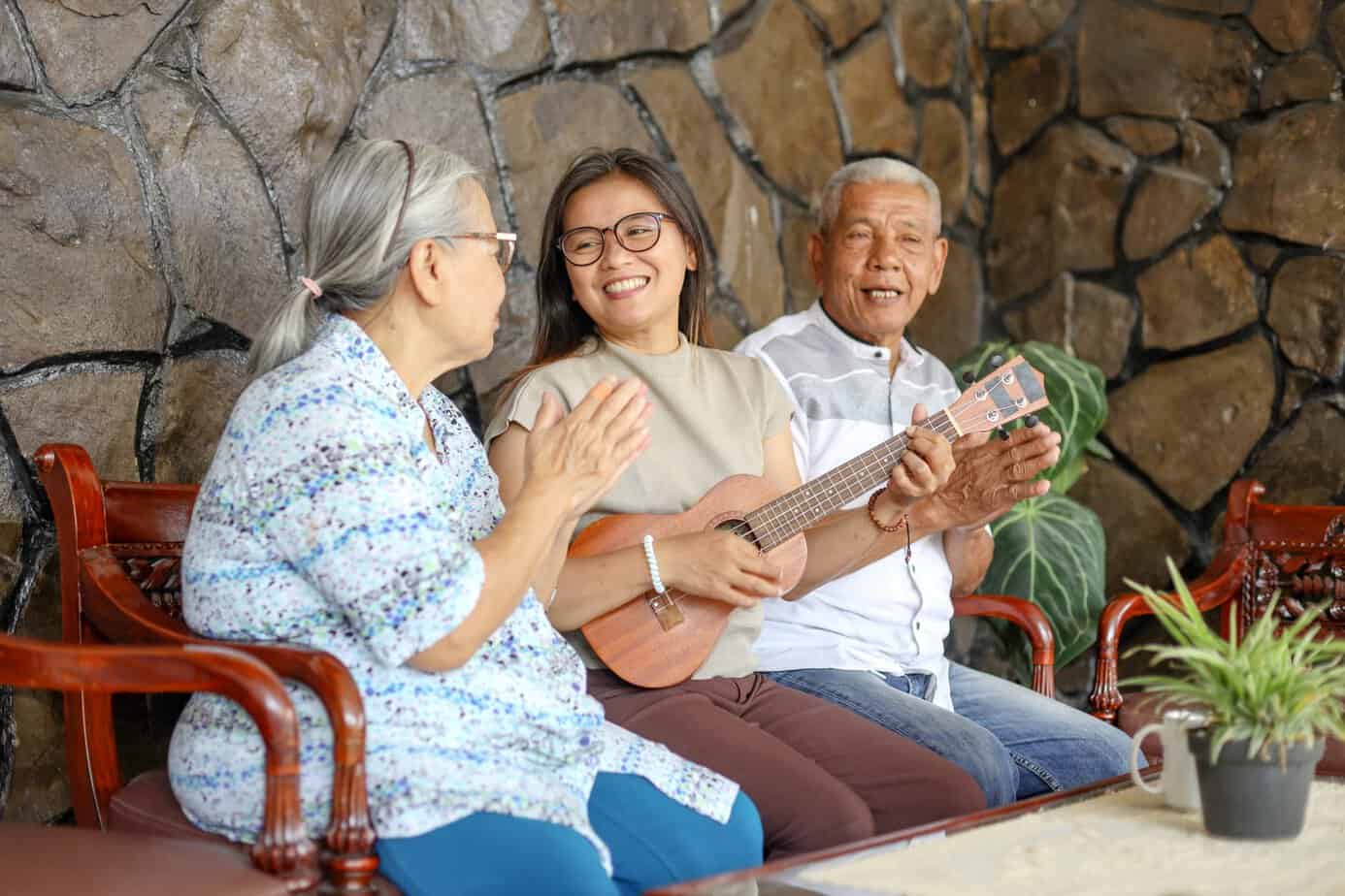 three-people-enjoying-music-together-at-home-2026-03-18-04-25-45-utc Family members share music with older adults during a visit, illustrating the health benefits of music for memory, mood, and social connection