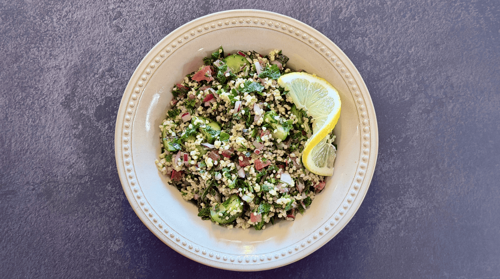 gluten-free-tabbouleh-with-millet Gluten-Free Tabbouleh with millet, parsley, mint, cucumber, tomato, and lemon in a cream-colored bowl